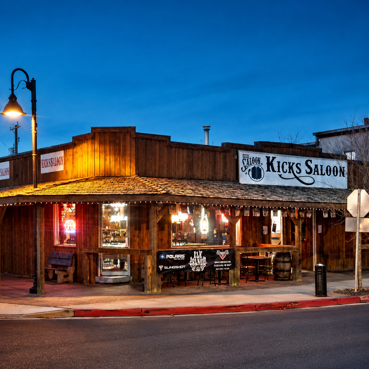 Kicks Saloon's timber storefront lit up at dusk on 49 Avenue, Redwater