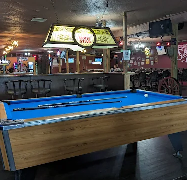 The pool table under a Lone Star lamp